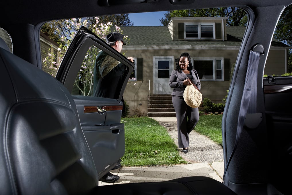 Businesswoman being picked up by chauffer